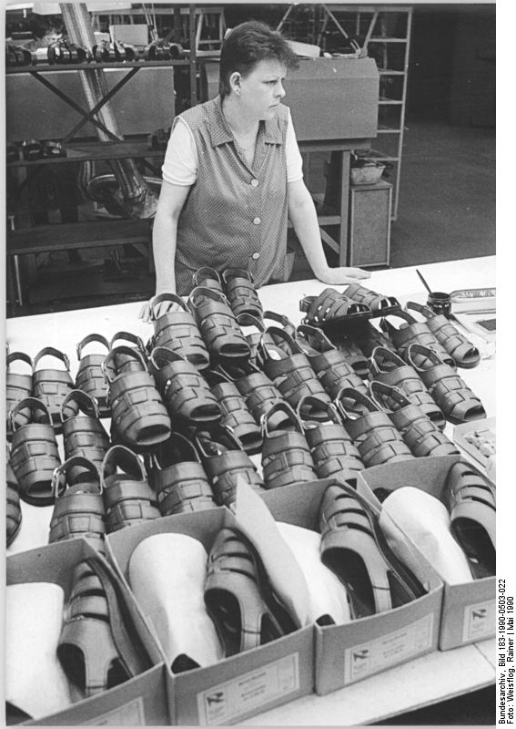 Arbeiterin aus der Schuhfabrik Lauchhammer im Mai 1990. Obwohl die Fabrik erst 1989 eröffnet wurde können die dort gefertigten Schuhe aufgrund der hohen Produktionskosten nicht mehr verkauft werden. Quelle: Bundesarchiv, Bild 183-1990-0503-022, Fotograf: Rainer Weisflog